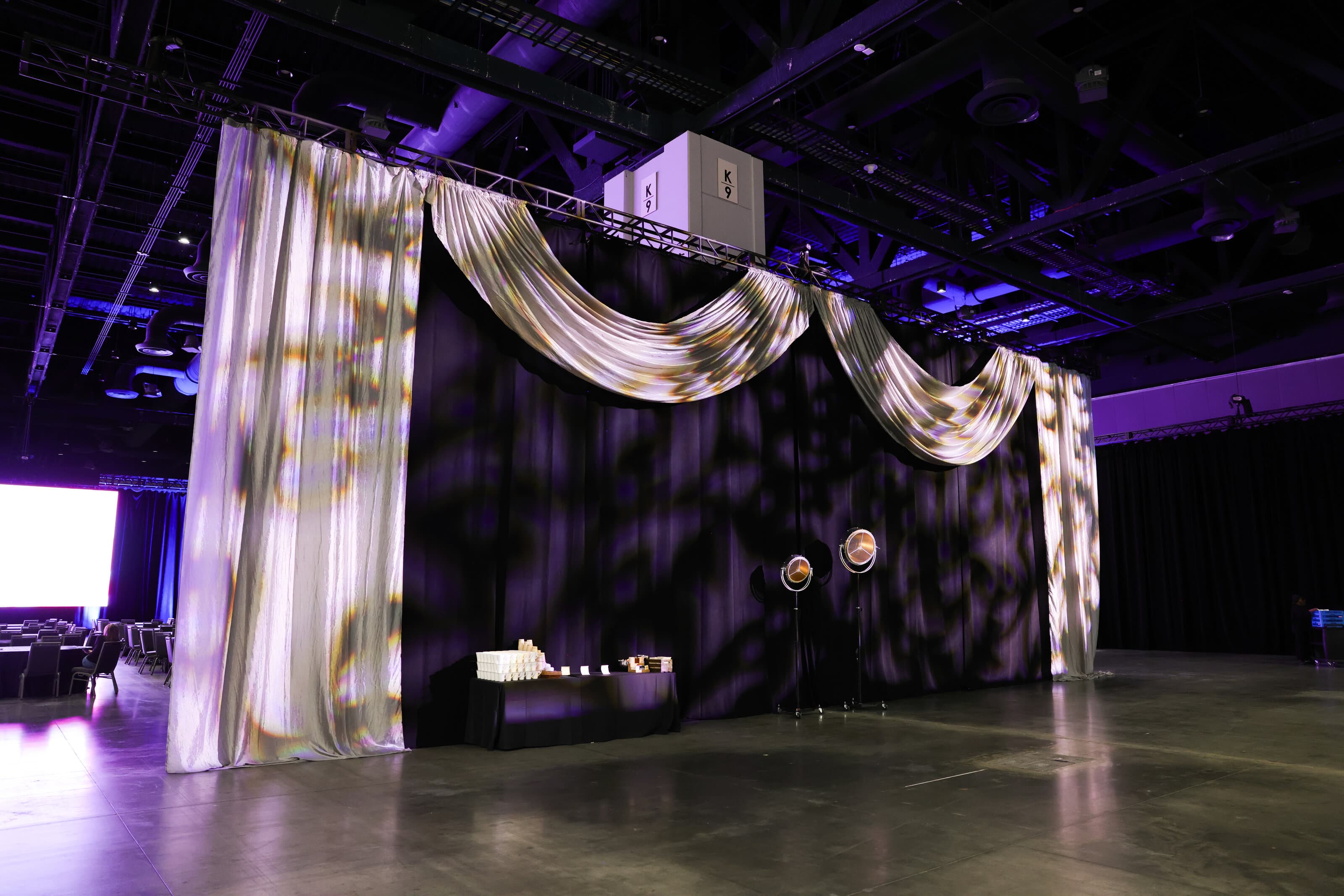 Draped room with suspended LED and audio elements