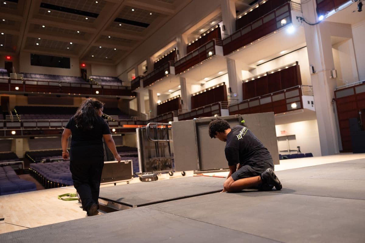 Crew setting staging decks in a performing arts hall