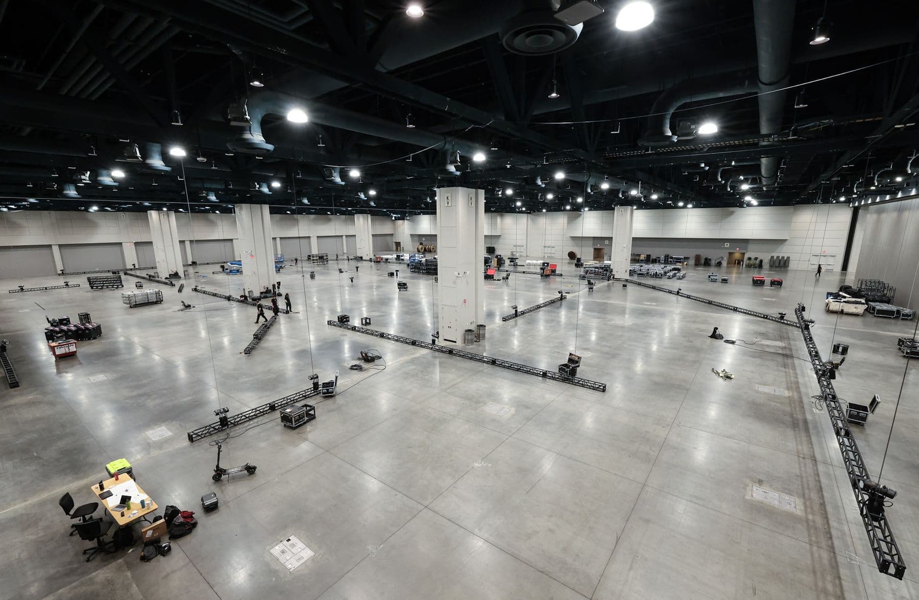 Convention hall load in with truss runs and road cases across the floor