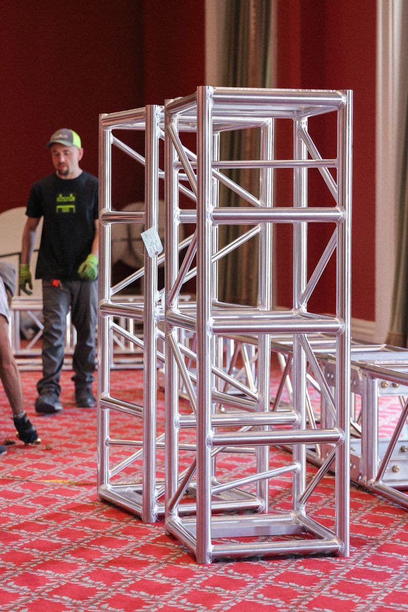 OnPoint crew member building an aluminum truss tower in a ballroom