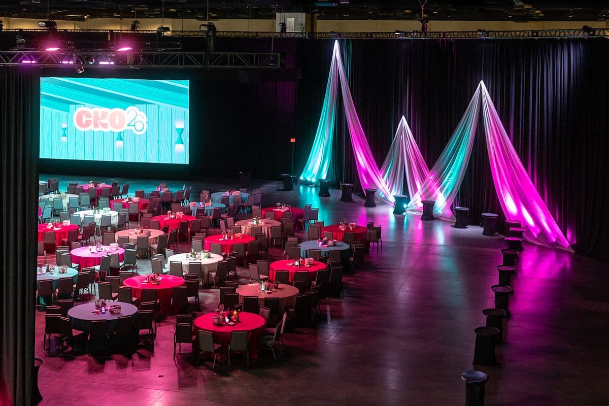 Banquet room wrapped in drape with a large LED wall and theatrical uplighting