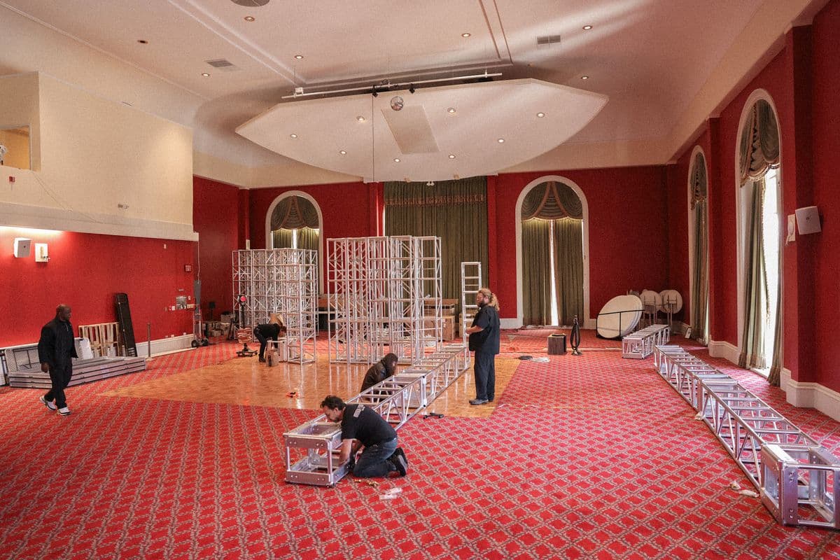 Truss structures being assembled across a ballroom floor