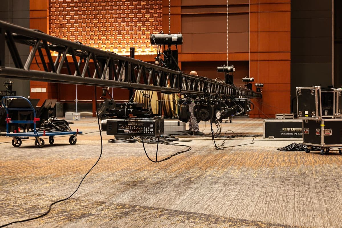 Truss run fitted with lighting fixtures on a venue floor before the lift